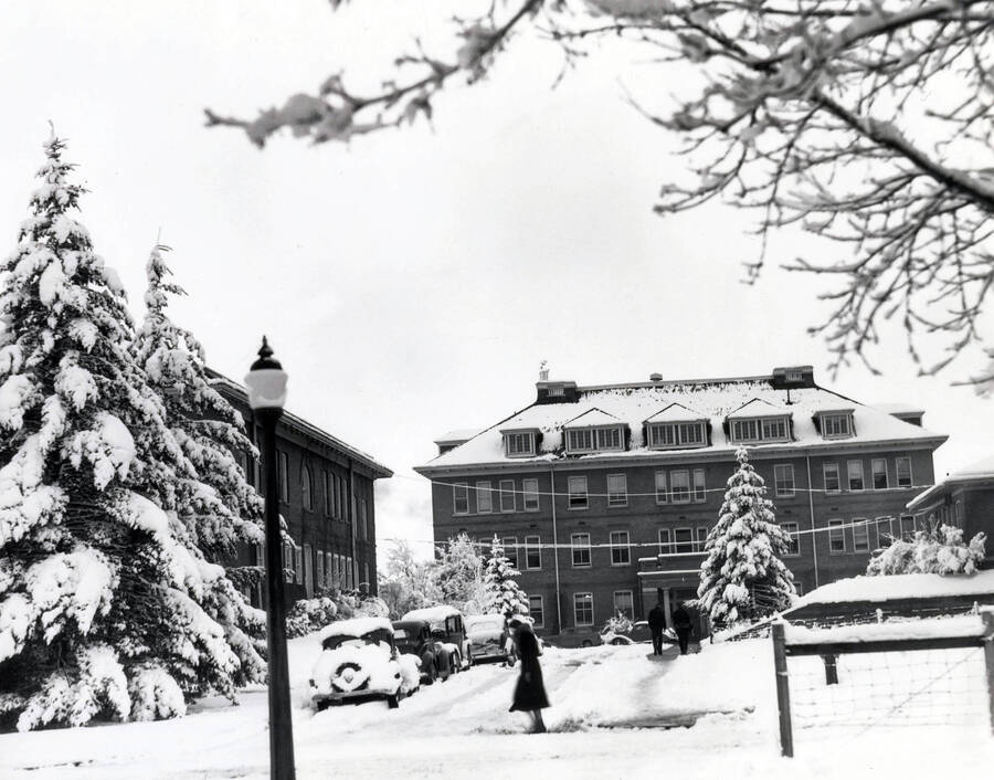1949 photograph of Morrill Hall. View of students walking to class in the snow. [PG1_66-18]