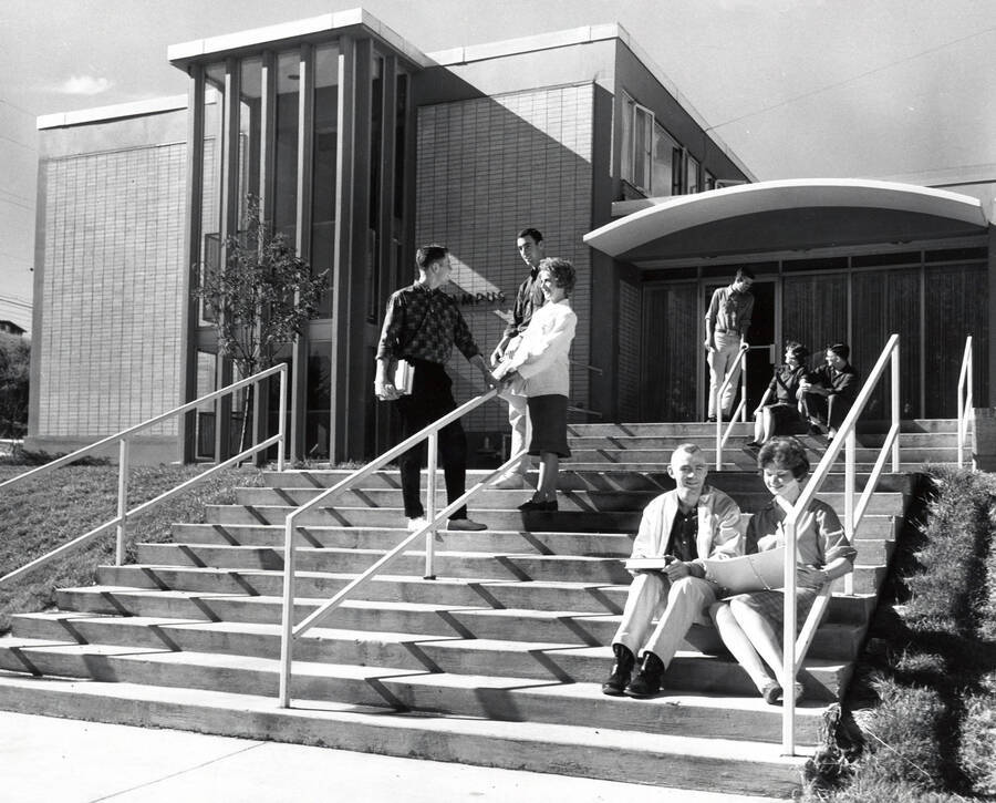 1961 photograph of Campus Club. View of students next to building entrance.[PG1_073-02]