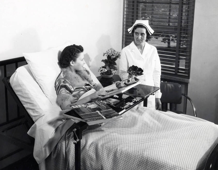 1938 photograph of Infirmary. Patient has magazines on her bed tray including a May 1938 issue of 'Life'. [PG1_074-10]
