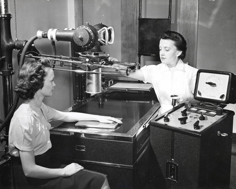 1938 photograph of Infirmary. Nurse x-rays student's arm. [PG1_074-14]