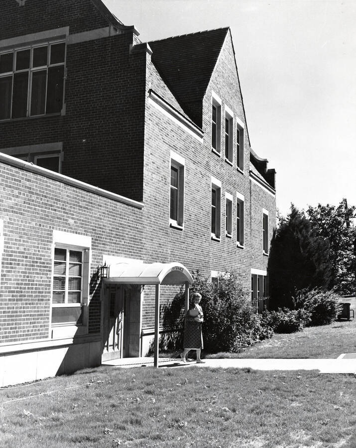 1950 photograph of Infirmary. Woman exits through the side entrance. Donor: Publications Dept. [PG1_074-23]