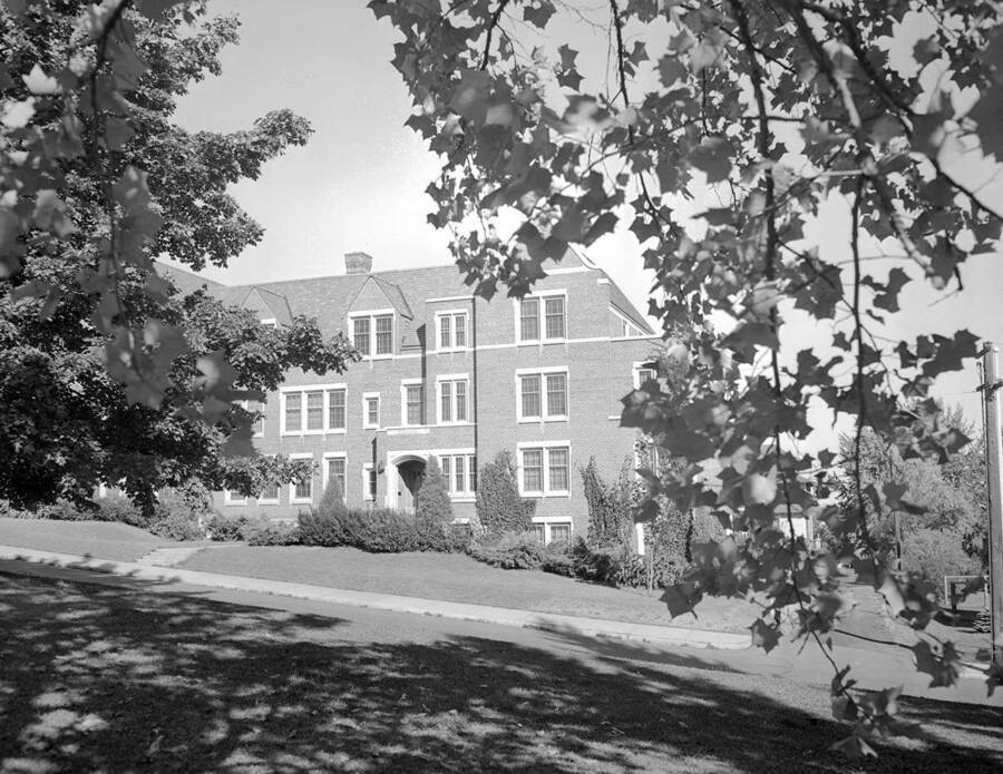 1940 photograph of Infirmary. Building framed by trees. [PG1_074-29]