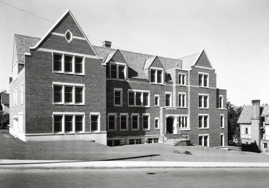 1937 photograph of Infirmary. View of the front with a fraternity visible on the right. [PG1_074-03]