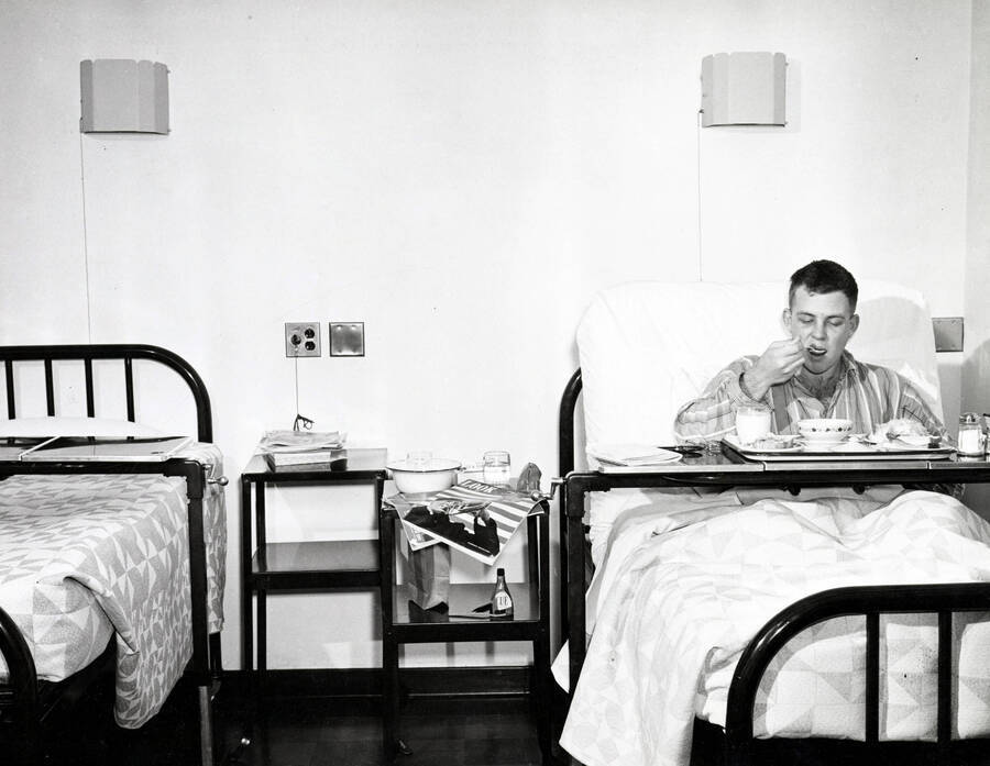 1937 photograph of Infirmary. Patient eats his meal. [PG1_074-09]