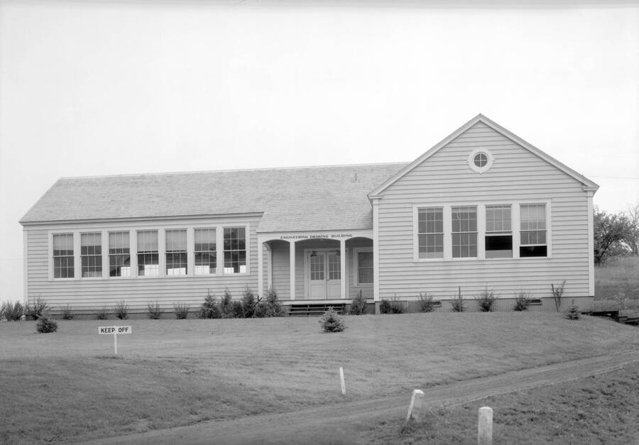 1935 photograph of Industrial Arts Building. 'Keep Off' signs on the new lawn. [PG1_080-7]