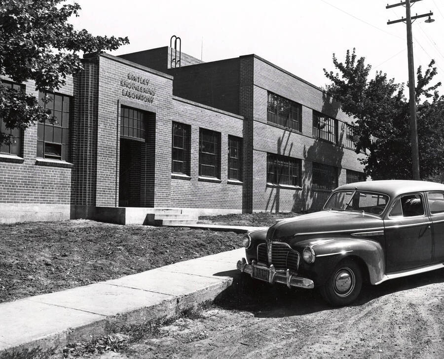 1942 photograph of Kirtley Engineering Laboratory. Automobile parked on the dirt road at entrance. Donor: Publications Dept. [PG1_084-05a]