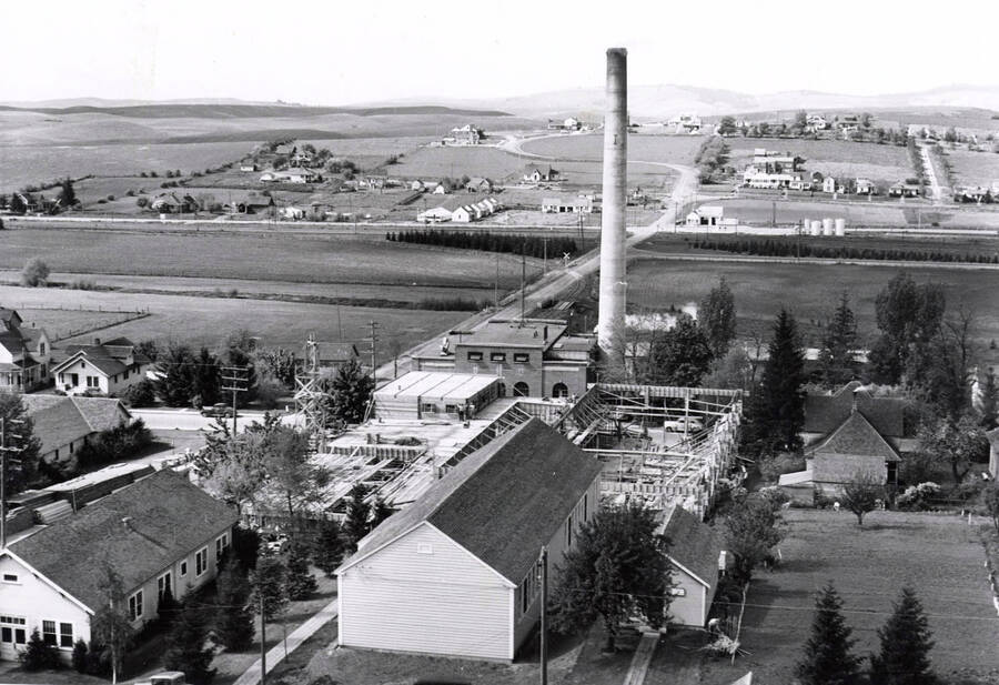1942 photograph of Kirtley Engineering Laboratory. View of construction with power plant stack and farms in the background. [PG1_084-03]