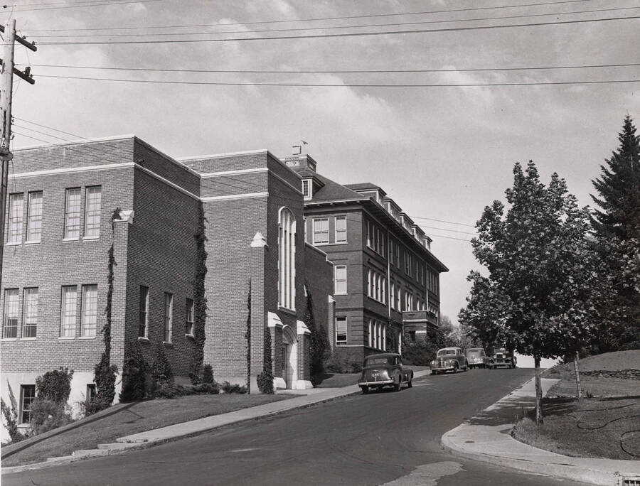 1948 photograph of Dairy Science Building. View looking east from Idaho, automobiles parked in front. [PG1_092-11]