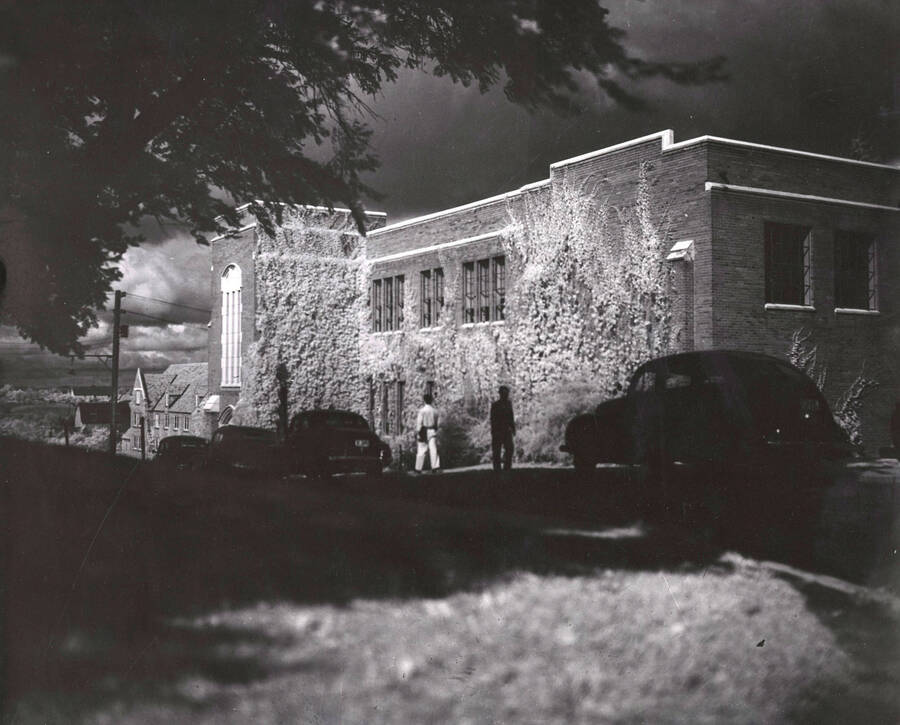 1948 photograph of Dairy Science Building. View at night looking west from Idaho, automobiles parked in front. Donor: Publications Dept. [PG1_092-13]