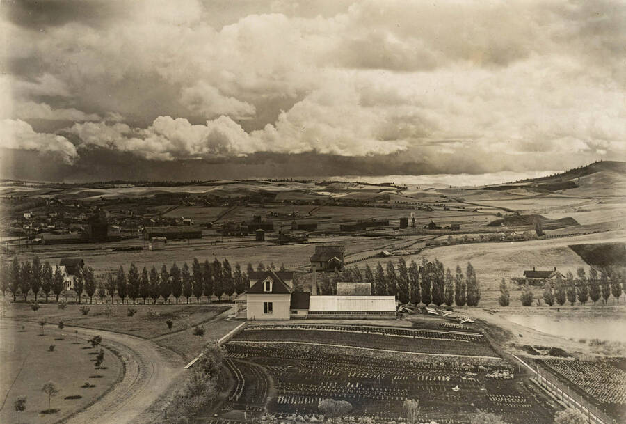 1900 photograph of Horticulture Building. View of the planting plots in the foreground and farms in the back. [PG1_094-09]