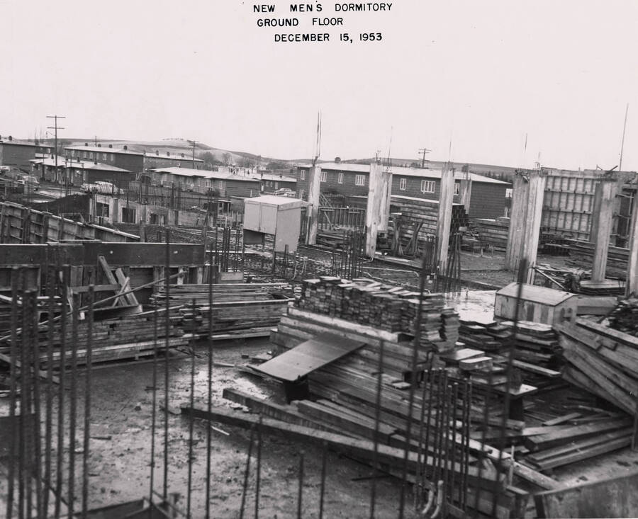 December 15, 1953 photograph of Gault Hall under construction. Planks of wood in the foreground. [PG1_095-12a]