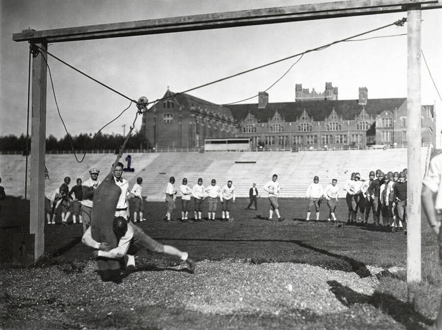 1923 photograph of MacLean Field. Administration Building in background. Charlie Erb coaching student athletes. [PG1_098-06]