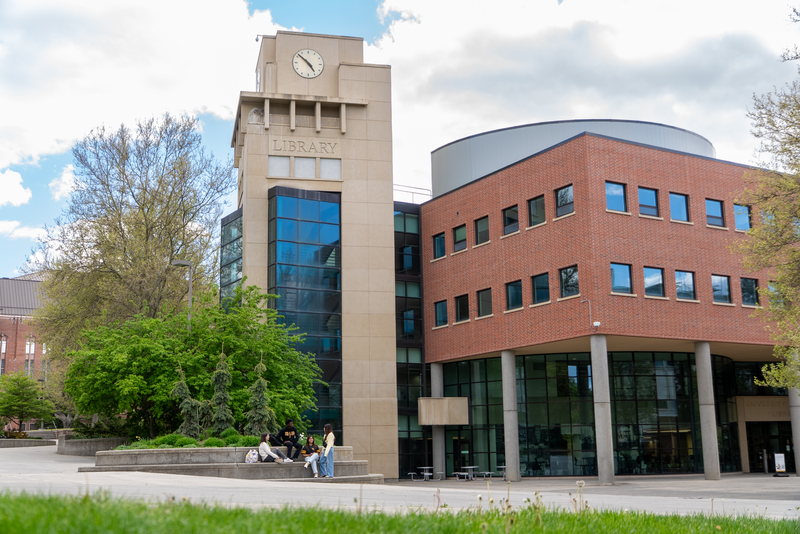 Students gather in front of the library tower in spring