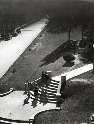 1942 photograph of the Hello Walk steps. Students on the stops and automobiles in background.