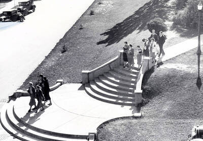 1940 photograph of the Hello Walk steps. Students on steps and automobiles in background.