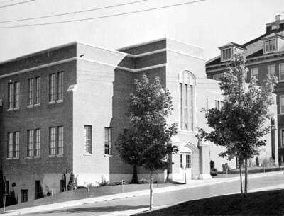 1943 photograph of the Dairy Science Building. Morill Hall in background, trees in foreground.