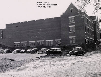 July 15, 1951 photograph of the Music Building under construction. Automobiles in foreground.