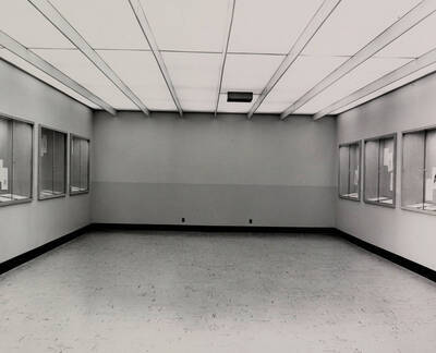 1957 photograph of the Library. Large open room with display cases to the left and right.