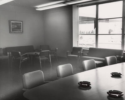 1957 photograph of the Library. Large conference room with ashtrays in foreground.