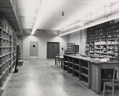 1957 photograph of the Library. Shipping and receiving area with shelves to the left and right.