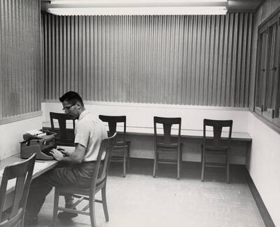 1957 photograph of the Library. A student works in the typing room.