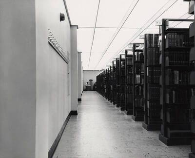 1957 photograph of the Library. A student works at a carrel in the background.
