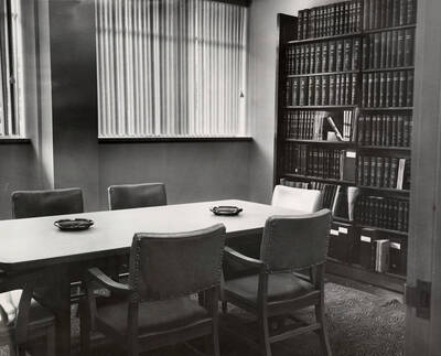 1957 photograph of the Library. Scene of conference room complete with ashtrays.