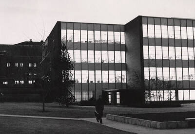1957 photograph of the Library. A student walks away from the building at night.