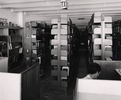 October 1, 1982 photograph of the Library. A student studies at a desk to the right.