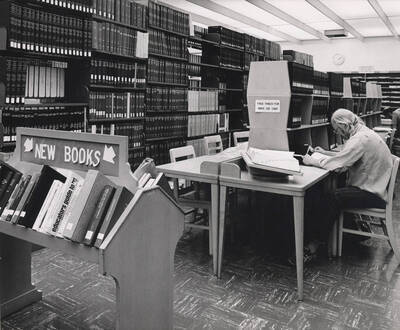 October 1, 1982 photograph of the Library. A student studies near index stacks.