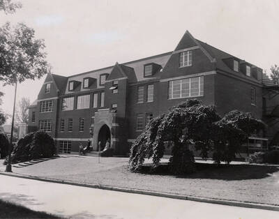 1953 photograph of the Home Economics Building. Students on the steps in background.