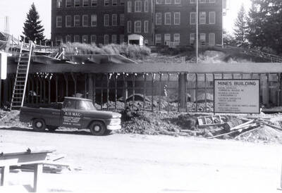 1960 photograph of the Mines Building under construction. Automobile in foreground. Donor: College of Mines.