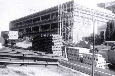 1960 photograph of the Mines Building under construction. Automobiles in foreground. Donor: College of Mines.