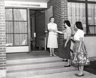 1955 photograph of the Permeal J French House. Left to right: Harriet Cummerford, Permeal French House Hostess, Charlotte Aldus, Lois Seubert. Donor: Publications Dept.