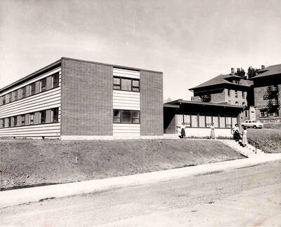 1954 photograph of the Permeal J French House. Students in foreground, Ridenbaugh Hall in background. Donor: Publications Dept.