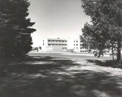 1961 photograph of Shoup Hall. Trees in foreground.
