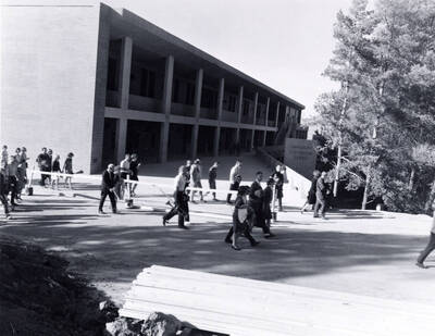 1965 photograph of University Classroom Center. Group of people in foreground.