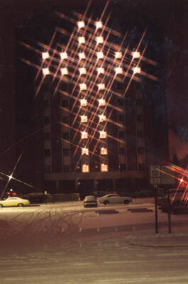1984 photograph of the Donald R Theophilus Residence Hall. Windows lighted as a cross at night. Donor: Stanley A. Shepard.