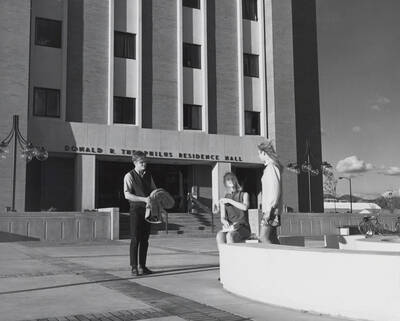 1969 photograph of the Donald R Theophilus Residence Hall. Students near entrance. Donor: Publications Dept.