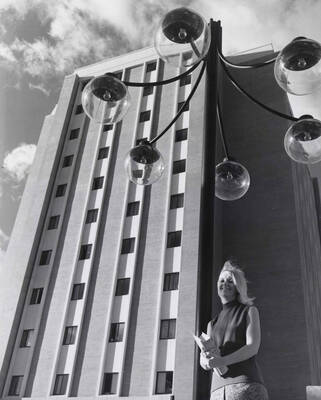 1969 photograph of the Donald R Theophilus Residence Hall. Student in foreground next to lamp post. Donor: Publications Dept.