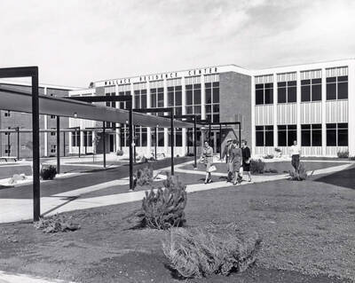 1966 photograph of the Wallace Residence Center. A group of students walks away from the building.