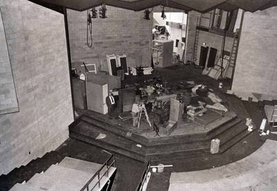 1975 photograph of Hartung Theatre. Students build a set on stage.