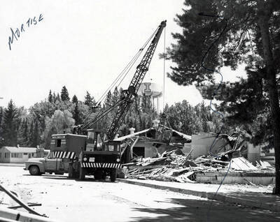 1966 photograph of Temporary Classroom Building #1 under demolition. Water tower in background. Donor: Publications Dept.