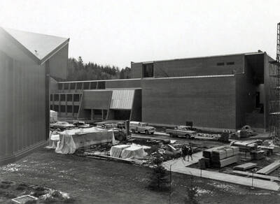 1970 photograph of the Physical Education Building under construction. Students and automobiles in foreground. Donor: Publications Dept.