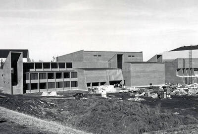 1969 photograph of the Physical Education Building under construction. Construction equipment and automobiles in foreground.