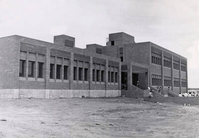 April 27, 1974 photograph of the Menard Law Building dedication ceremony. Group of people in background.