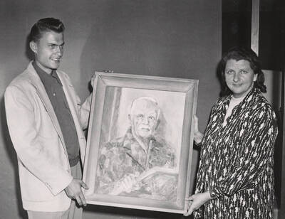 October 3, 1952 photograph of the James Memorial Clubhouse dedication ceremony. L.D. Faylor and Mrs. James with a painting of Francis L. James. Donor: Publications Dept.