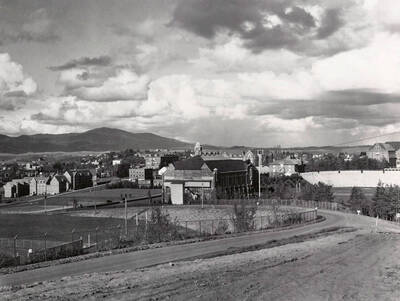 1930 panoramic photograph of University of Idaho campus. A southwest view of Memorial Gym in center and the grandstands to the right.