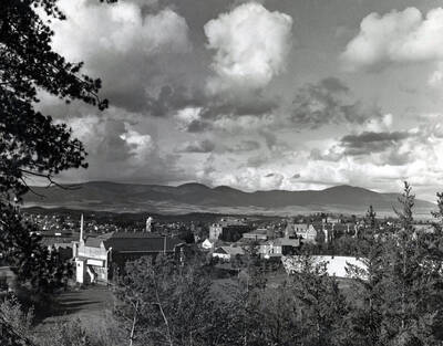 1930 panoramic photograph of University of Idaho campus. Grandstands in the foreground and Moscow Mountain in the background.