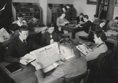 1936 photograph of the Library. Students read periodicals in the reading room.